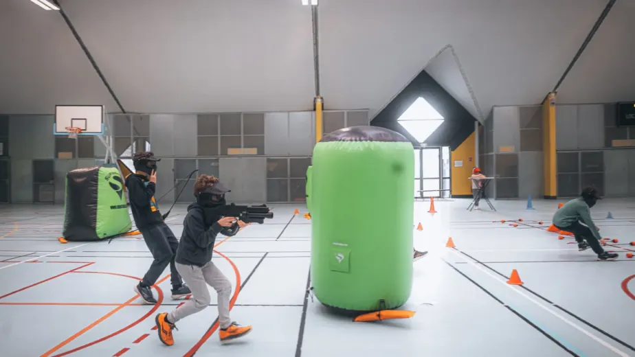 Enfants jouant au laser game dans une salle équipée de structures gonflables