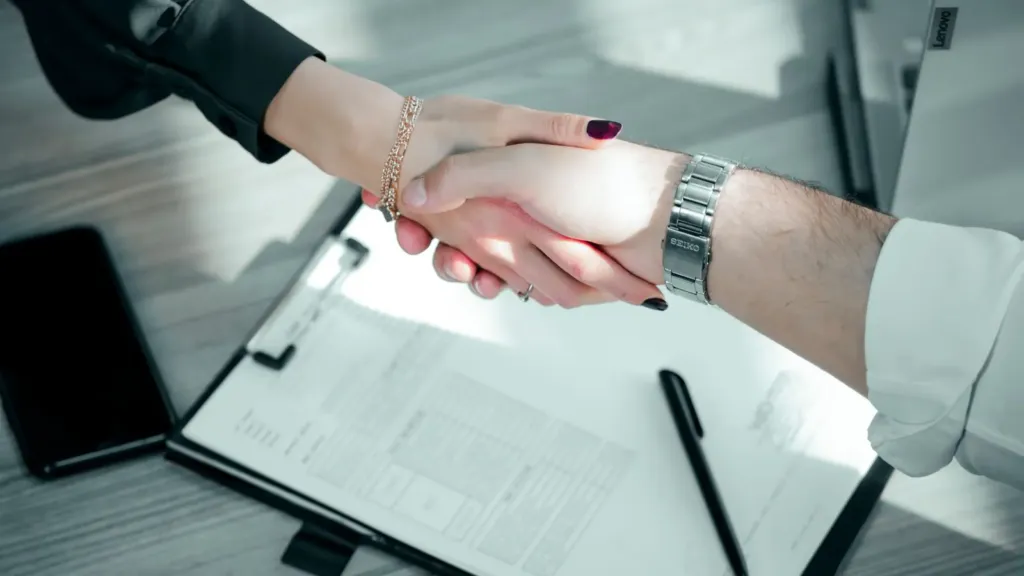 Poignée de main au-dessus d'un contrat de partenariat entre un club et une entreprise