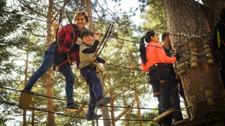 Famille progressant sur un parcours d'accrobranche en forêt