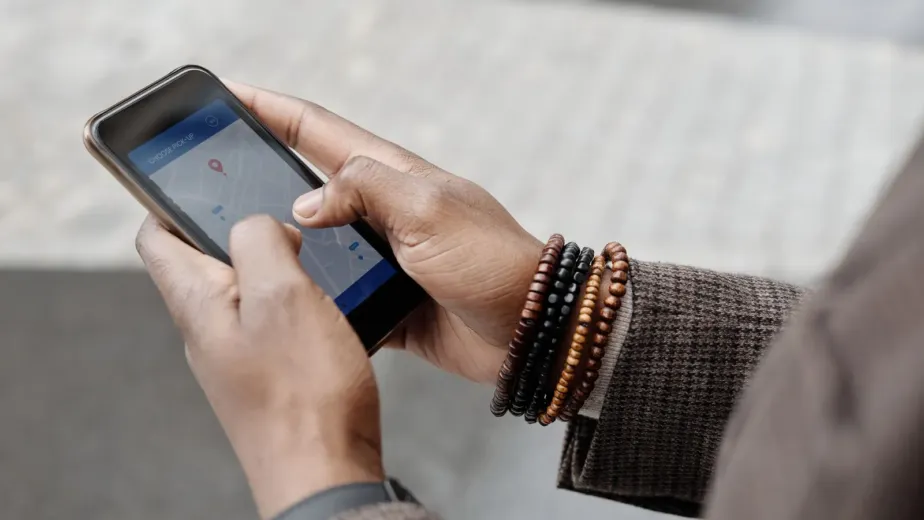 Mains tenant un smartphone affichant une carte pour trouver une activité à proximité