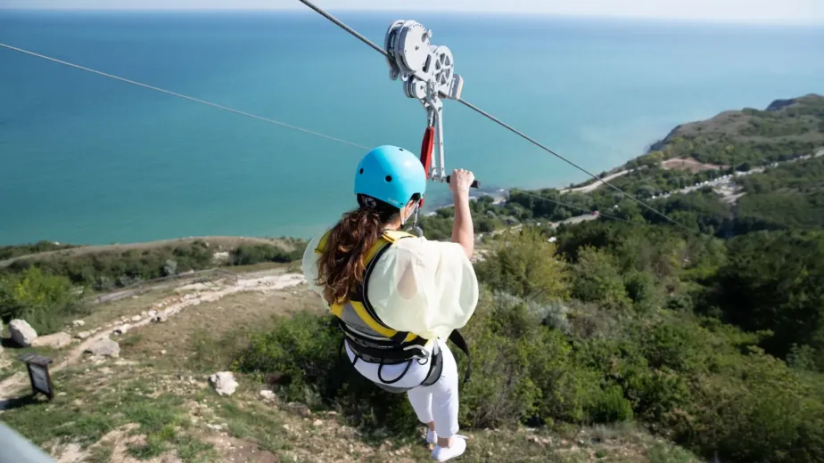Femme descendant une tyrolienne au-dessus de la mer