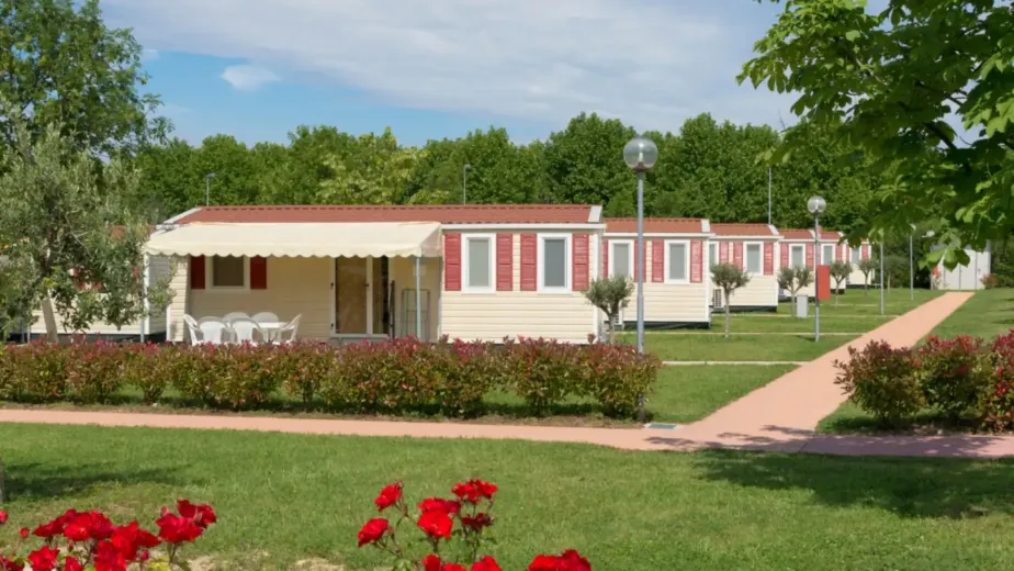 Mobil-homes alignés dans un camping fleuri et arboré