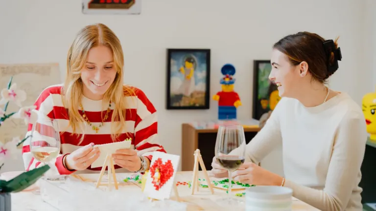 Deux participantes créant des objets en briques colorées lors d'un atelier chez Brick Room